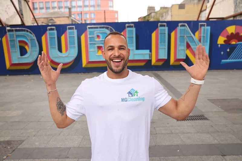 Hugo, founder of HG Cleaning, in front of a Dublin mural